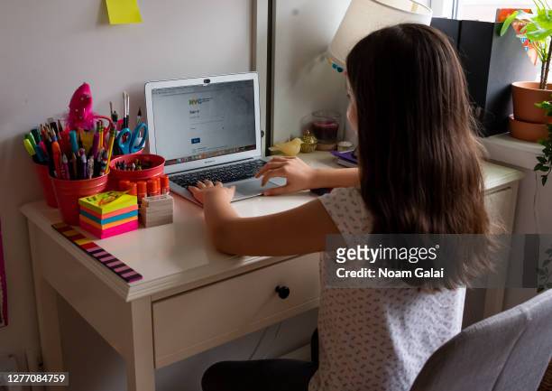 Kid sits in front of her computer as she does homeschooling at her home as the city continues Phase 4 of re-opening following restrictions imposed to...