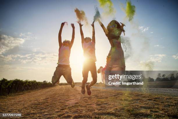 niños disfrutando lanzando polvo de colores - powder throw fotografías e imágenes de stock