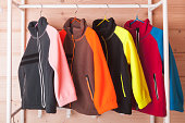 Colorful fleece jackets are hanging on hangers