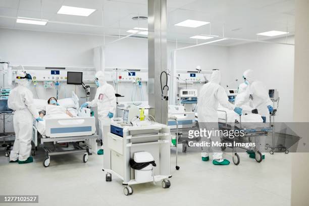 healthcare workers treating coronavirus patients during pandemic - intensive care unit stock pictures, royalty-free photos & images