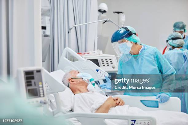 arts die aan hogere patiënt in het ziekenhuis tijdens covid-19 spreekt - icu stockfoto's en -beelden