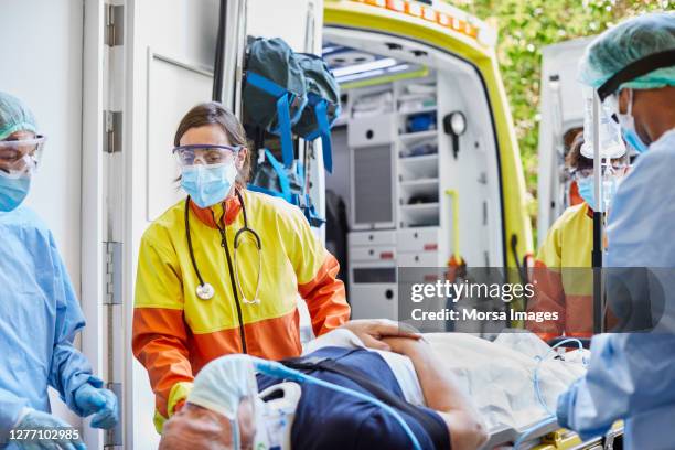 healthcare workers bringing male patient on stretcher - ambulance arrival stock pictures, royalty-free photos & images