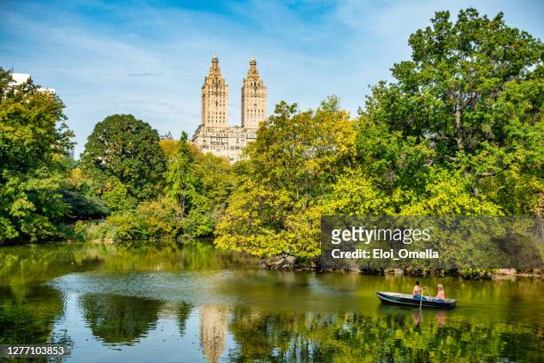beautiful lake with raw boats in new york central park - central park manhattan stock pictures, royalty-free photos & images