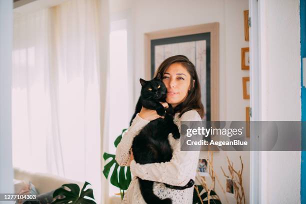 cute woman hugging her black cat - woman holding kitten stock pictures, royalty-free photos & images