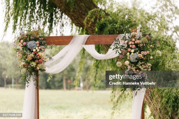 wedding arch decorated with flowers and greenery in rural area - garden decoration stock pictures, royalty-free photos & images