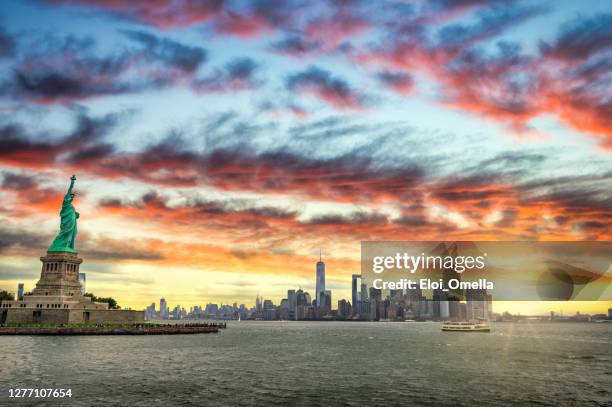 sonnenaufgang in ney york city - new york freiheitsstatue stock-fotos und bilder