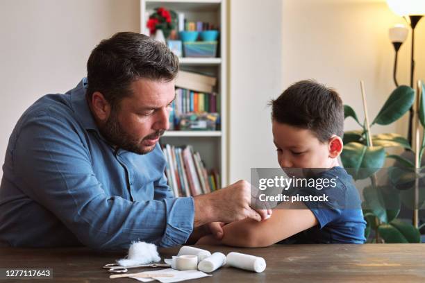 father and child first aid - first aid stock pictures, royalty-free photos & images