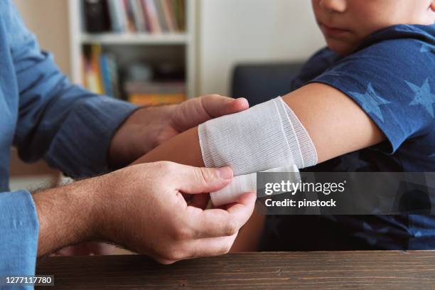 primo soccorso padre e figlio - fasciatura foto e immagini stock