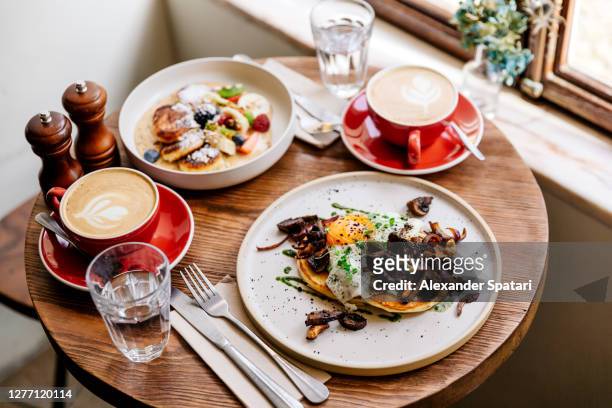 brunch with savoury pancakes and cottage cheese pancakes served with cappuccino - plate side view stock pictures, royalty-free photos & images