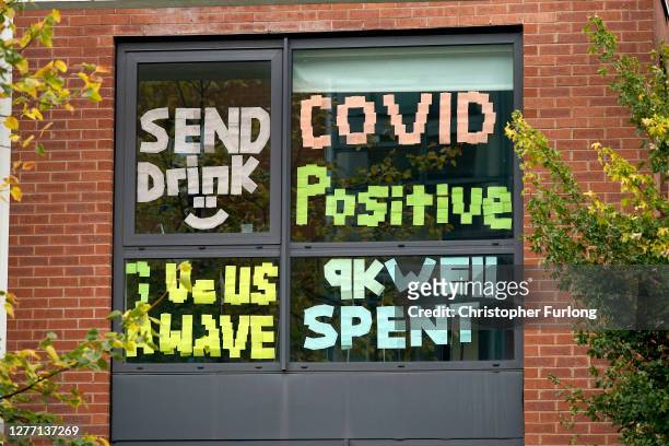 Signs made by students are displayed in a window of their locked down accommodation building on September 28, 2020 in Manchester, England. Around...