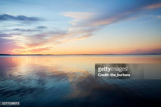 sunset by the sea, the sky is reflected in the sea - sunset stock-fotos und bilder