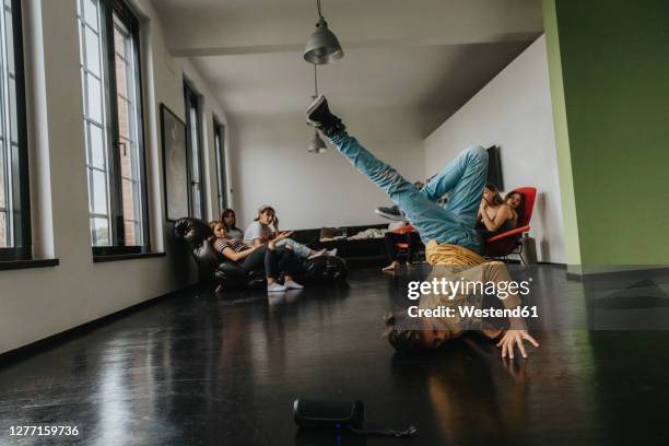 friends looking at boy breakdancing on floor - freestyle dance stock pictures, royalty-free photos & images