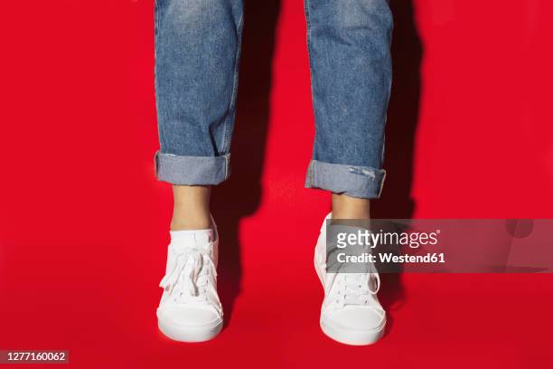 close-up of of woman on tiptoeing against red background - tiptoe imagens e fotografias de stock