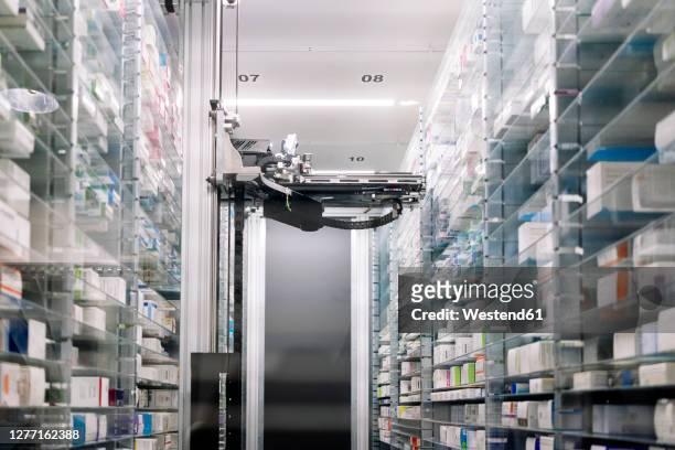 robotic pharmacy amidst shelves in hospital - storage compartment stock-fotos und bilder