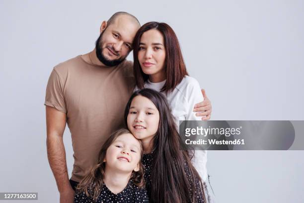 parents and children embracing while standing against white background - family photo shoot stock pictures, royalty-free photos & images