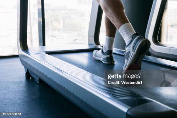 legs of male athlete running on treadmill in gym - male feet imagens e fotografias de stock