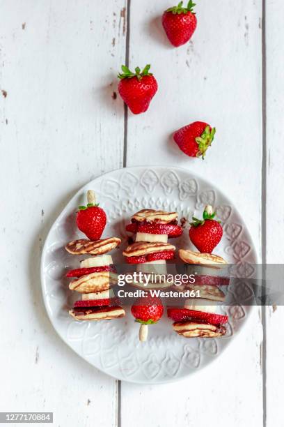 plate of mini pancakes with strawberries and bananas - bratspieß stock-fotos und bilder