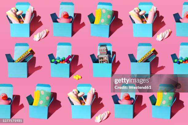 pattern of boxes with various gifts including harmonicas, plastic spheres, vintage robot toys, sweets, rubber ducks and socks - surprise gift foto e immagini stock