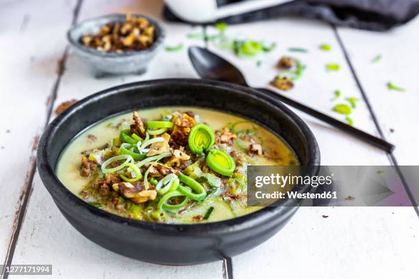 bowl of vegetarian leek soup with cheese and roasted walnuts - suppe stock-fotos und bilder