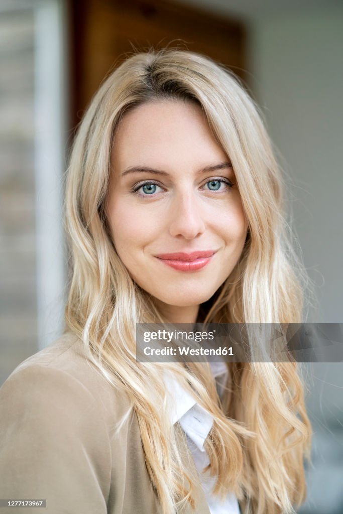 Close-up of smiling female entrepreneur with blond hair in office
