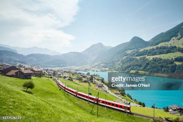 lush swiss landscape with commuter train and lake, lungern, obwalden, switzerland - schweiz stock-fotos und bilder