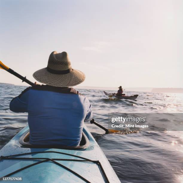 middle aged man and woman sea kayaking. - piragüismo y canotaje fotografías e imágenes de stock