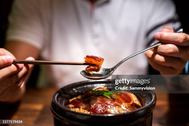 asian man eating dongpo pork in restaurant - hangzhou stock pictures, royalty-free photos & images