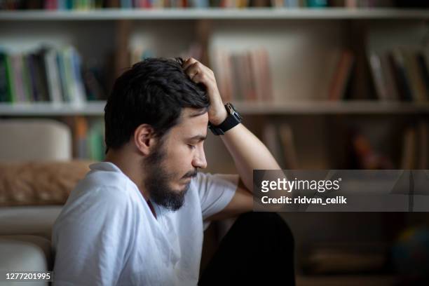 olycklig deprimerad kaukasiska manliga sittande - heartbreak bildbanksfoton och bilder