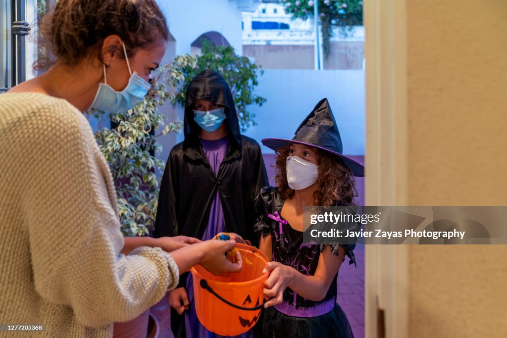 Children Dressed In Halloween Costumes Trick-Or-Treating In COVID-19 Times