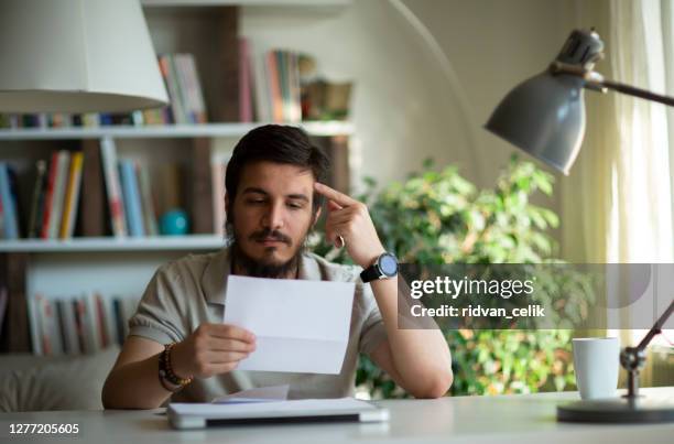 enfadado hombre estresado abrir sobre leyendo malas noticias en la carta - receiving documents fotografías e imágenes de stock