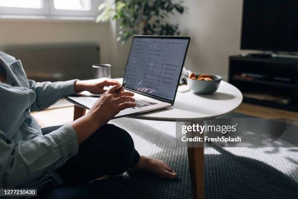 mujer anónima trabajando desde casa en su ordenador portátil pc - adaptable fotografías e imágenes de stock