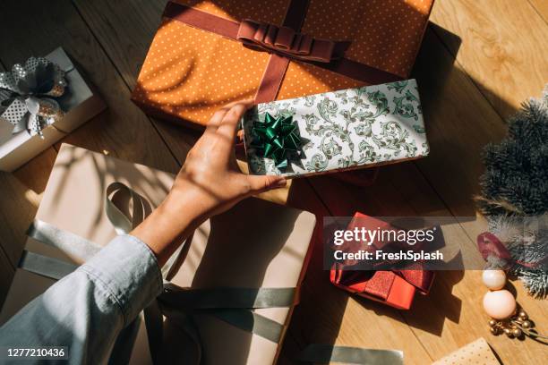 hand van een vrouw die een verpakte presentatie van kerstmis, een luchtmening houdt - christmas present stockfoto's en -beelden