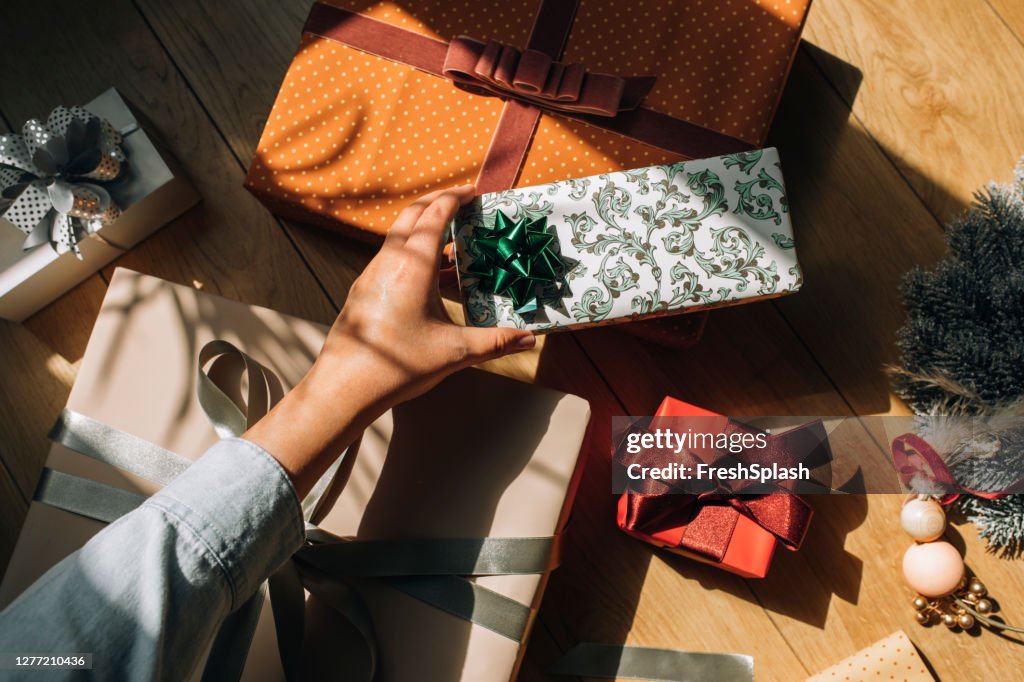 Hand of a Woman Holding a Wrapped Christmas Present, an Overhead View