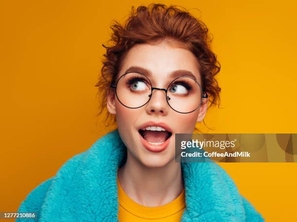 beautiful young girl in turquoise fur coat on a blue background - 2020 eyeglasses stock pictures, royalty-free photos & images