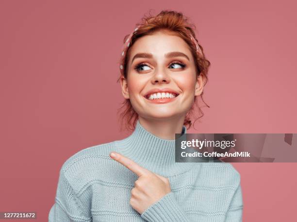 beautiful woman pointing at the side - woman on coloured background stock pictures, royalty-free photos & images