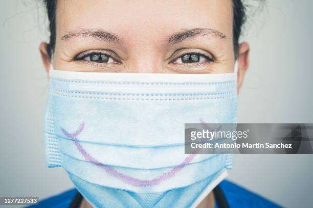 portrait of nurse with mask smiling - surgical mask stock-fotos und bilder