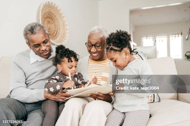 grandmother and grandfather with grandkids at home - legacy concept stock pictures, royalty-free photos & images