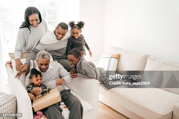 family with grandad opening presents - christmas photo album stock pictures, royalty-free photos & images