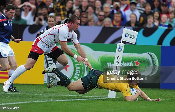 Drew Mitchell of Australiabreaks through the tackle of Vladimir Ostroushko of Russia to score during the IRB 2011 Rugby World Cup Pool C match...