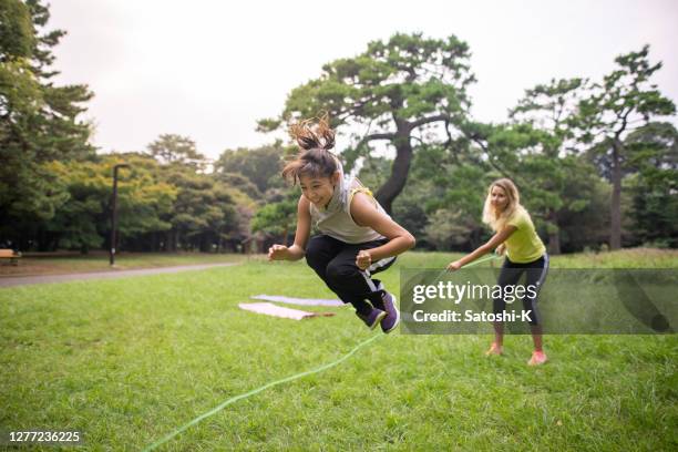 teenage girl playing with jumping rope with mother in public park - japan 12 years girl stock pictures, royalty-free photos & images