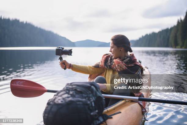 frau reisen mit kajak in der natur und vlogging. - camera boat stock-fotos und bilder