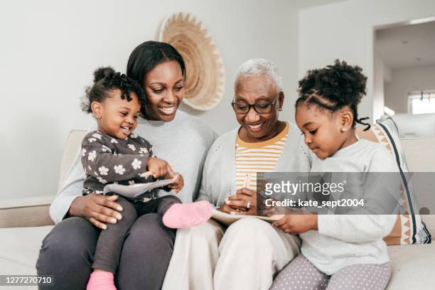 hogere vrouwen die tijd met kleinkinderen tijdens de wintervakantie thuis doorbrengen - legacy stockfoto's en -beelden