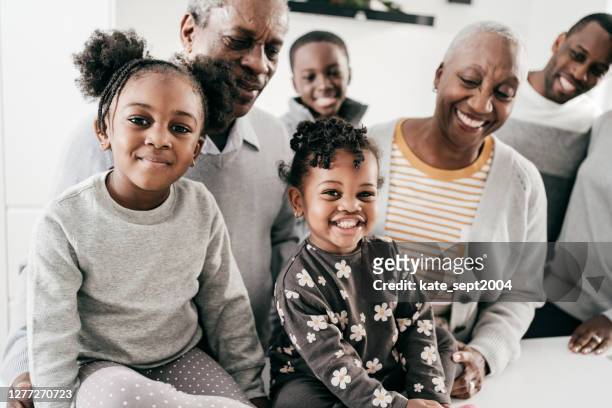 three generation family indoor gatherings during winter holidays - multi generation family winter stock pictures, royalty-free photos & images