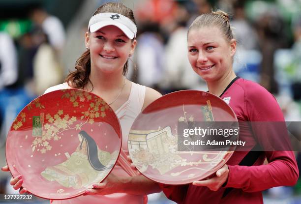 Angnieszka Radwanska of Poland celebrates victory with the winners plate and Vera Zvonareva of Russia the runner up after the final match between...