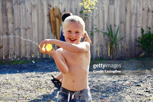 children water bomb fighting - kids water balloon fight stock pictures, royalty-free photos & images