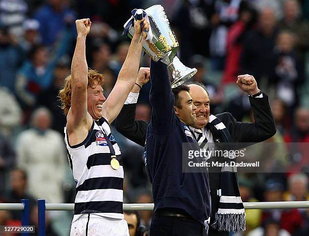 Cameron Ling captain and Chris Scott coach of the Geelong Football Club receive the premiership cup from club legend Doug Wade after winning the 2011...