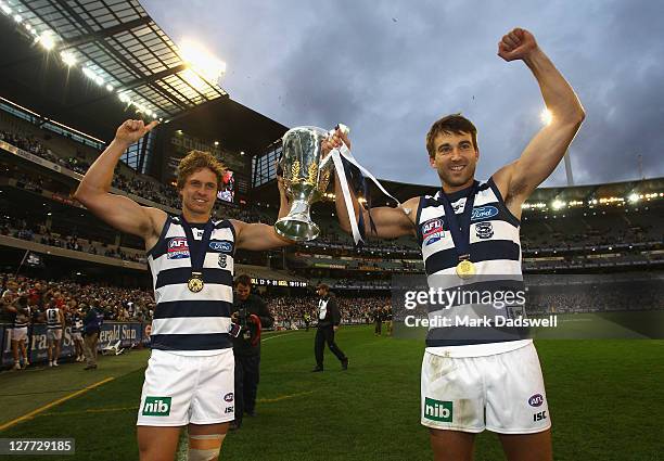 Mitch Duncan and Corey Enright of the Cats celebrate with the Premiership Cup after winning the 2011 AFL Grand Final match between the Collingwood...