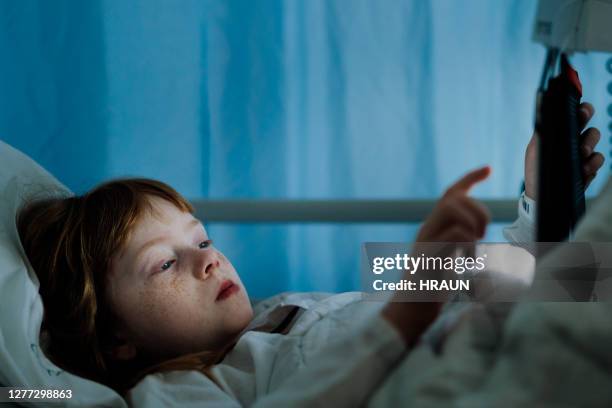 chica usando tablet pc en la cama en el hospital por la noche - apendicitis fotografías e imágenes de stock