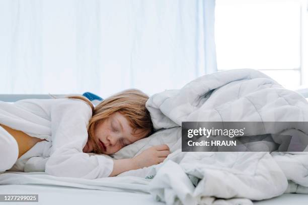 girl sleeping on bed in hospital ward - appendicitis imagens e fotografias de stock