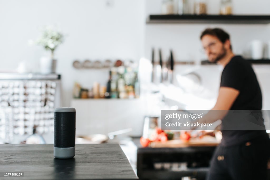 Volwassen mens vraagt kokend advies van slimme spreker